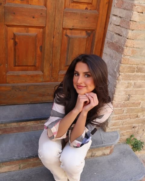 Lizzy Grace Sadorf seated on stone steps beside a wooden door